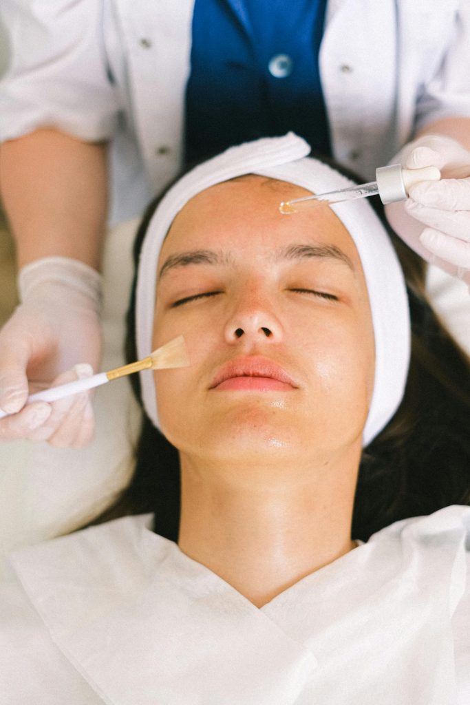 Dermatology professional applying cosmetic treatment product to patient face for acne scar treatment at Elect Dermatology in New Braunfels TX