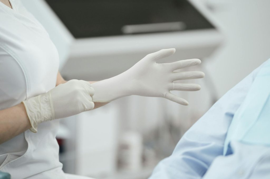 Medical professional wearing gloves preparing for dermatology skin treatment procedure at Elect Dermatology in New Braunfels TX